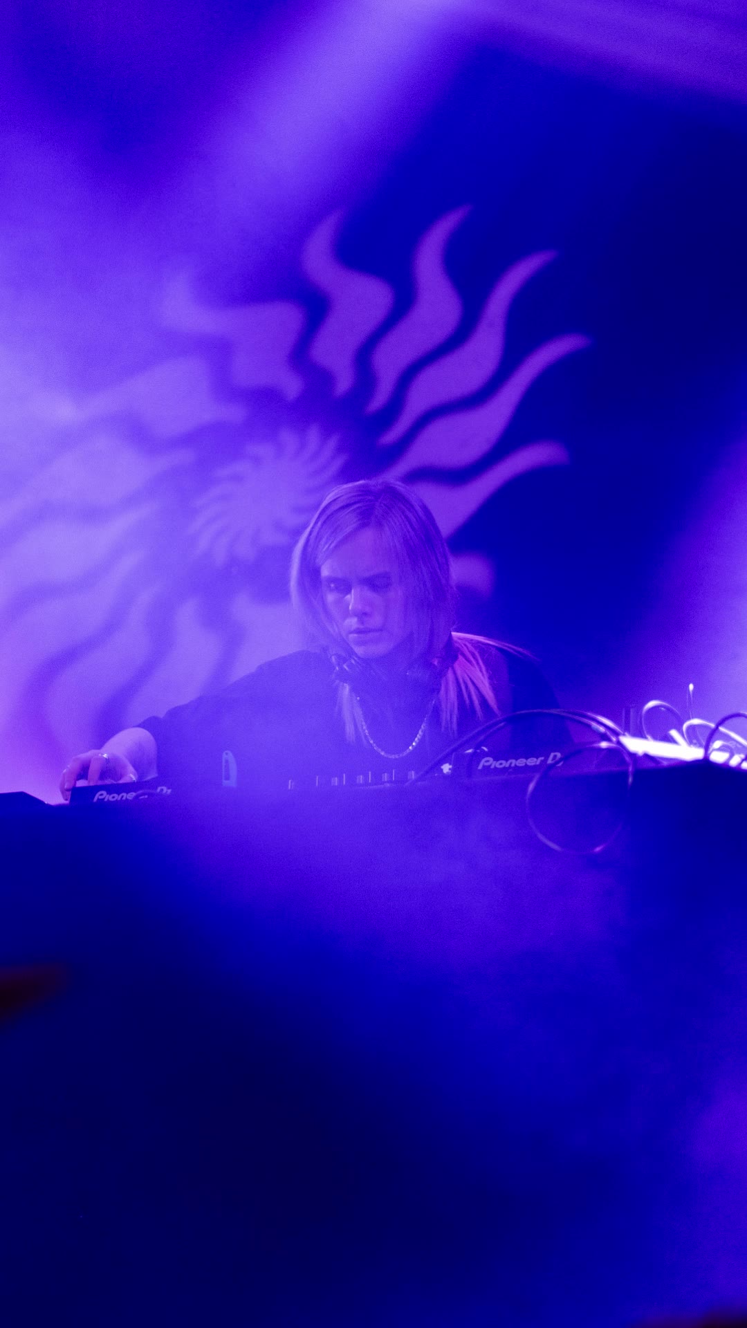 DJ in front of a purple sun projection